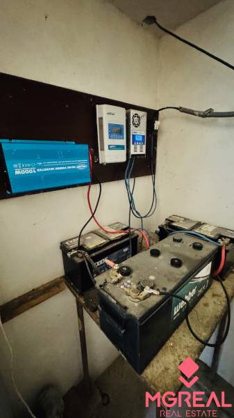 Akkumulátorok és inverter a ház technikai helyiségében, amelyek az elektromos telepítést és az áramellátást mutatják.