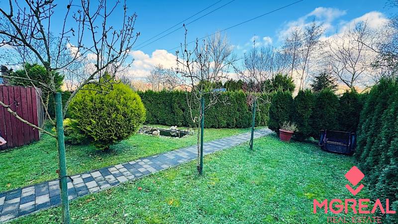 Kert a partizánskei háznál, rendezett sétánnyal és élő sövénnyel.