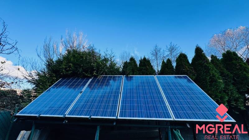 Napelemmel borított ház tetője Partizánskán, fákkal körülvéve.