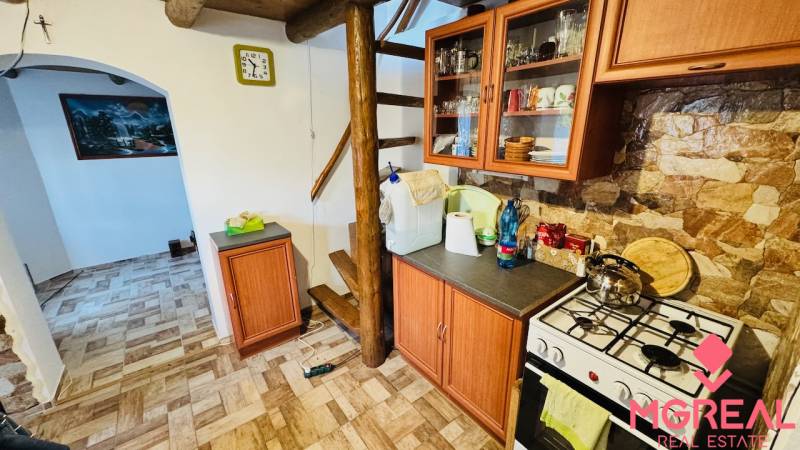 Konyha faházban fa dekorációval, lépcsőkkel, készülékekkel és bútorokkal, kőfallal.