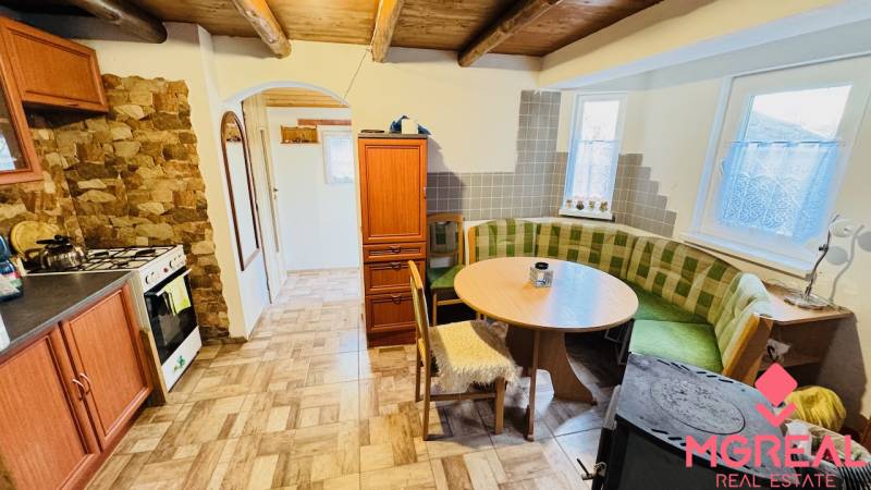 Rusztikus konyha a nyaralóban gáztűzhellyel és sarokkanapéval.