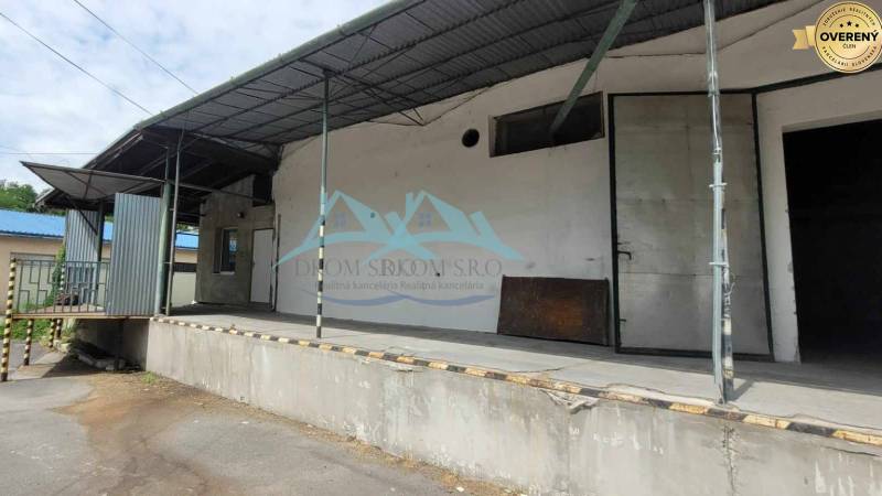 Fedett rakodórámpa a Vasút utcában, raktárak és acélszerkezetű csarnokok mellett.