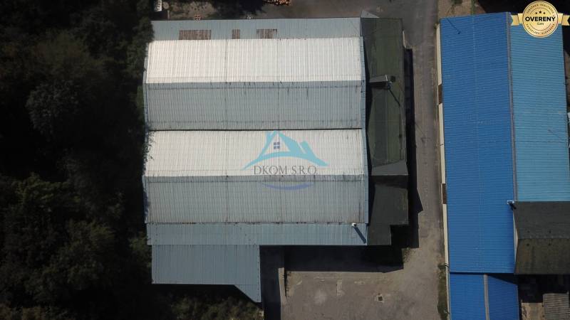 A Vasúti utcában nagy raktárépületek találhatók kék tetővel.