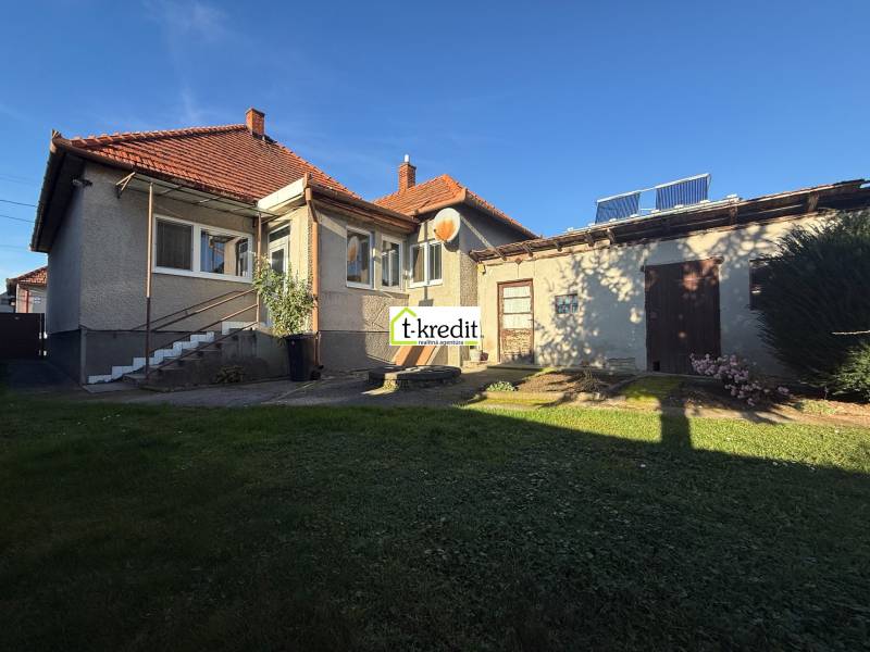 Családi ház Machulincén kerttel és melléképülettel, kék égen napsütéses nap.