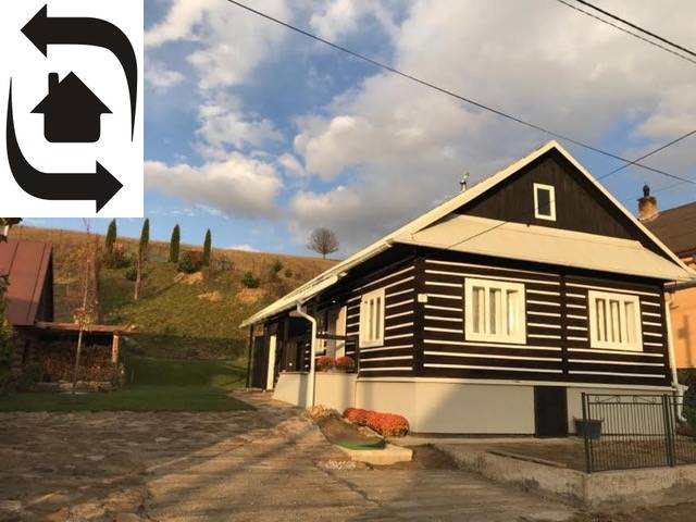 Faház Legnaván fa burkolattal és kövezett udvarral, természet és dombok veszik körül.