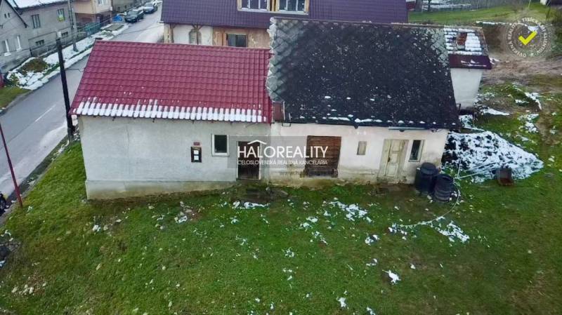 Régi családi ház Klenócon ferde tetővel a havas telken.