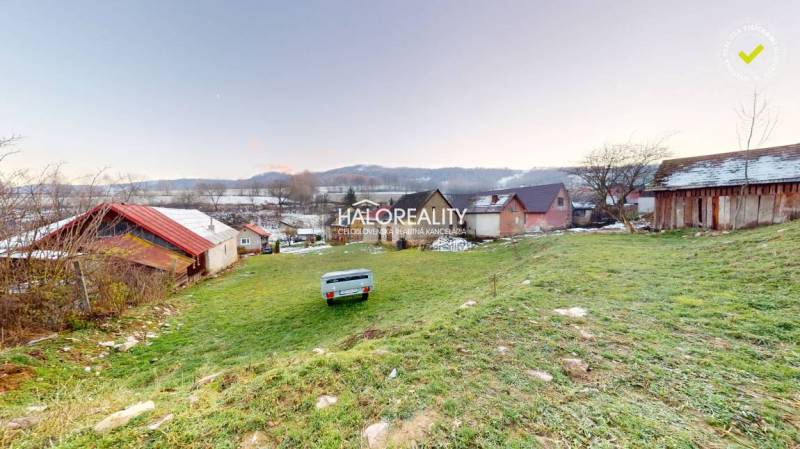 Egy családi ház hátsó udvara Klenócon, kilátással a rétekre és dombokra.