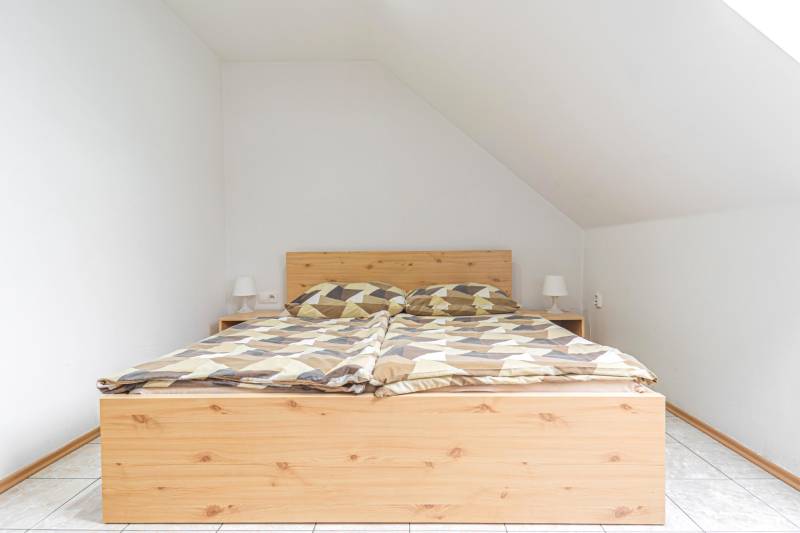 Ágy fa dekorációval és éjjeliszekrényekkel szállodákban és panziókban.