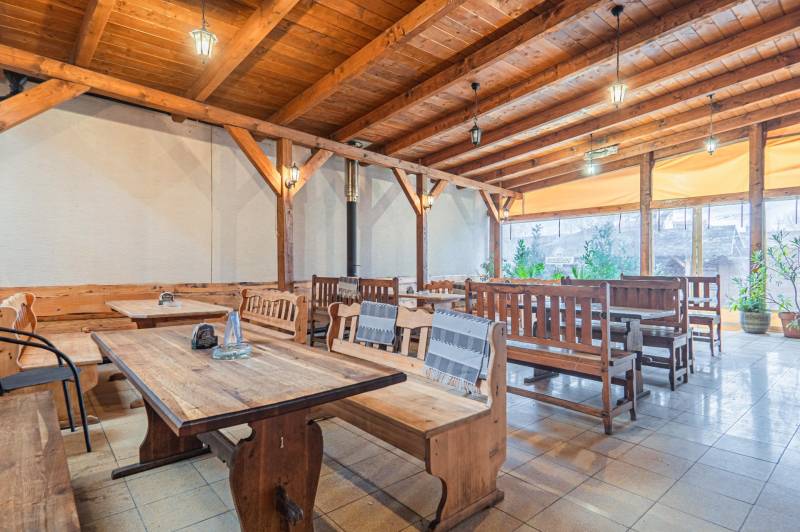 Fa asztalok és padok a belső térben, szállodák és panziók fa dekorációjú padlóval.