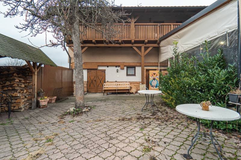 A Hollého utcai panzió udvara, Holíč, fa terasszal és fával.