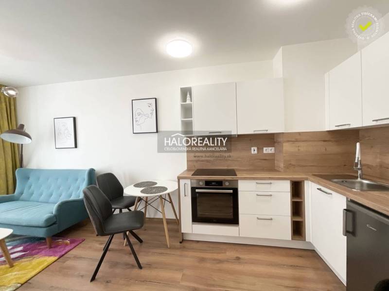 Konyha egy egyszobás lakásban, fa dekorációjú padlóval és világos bútorokkal.