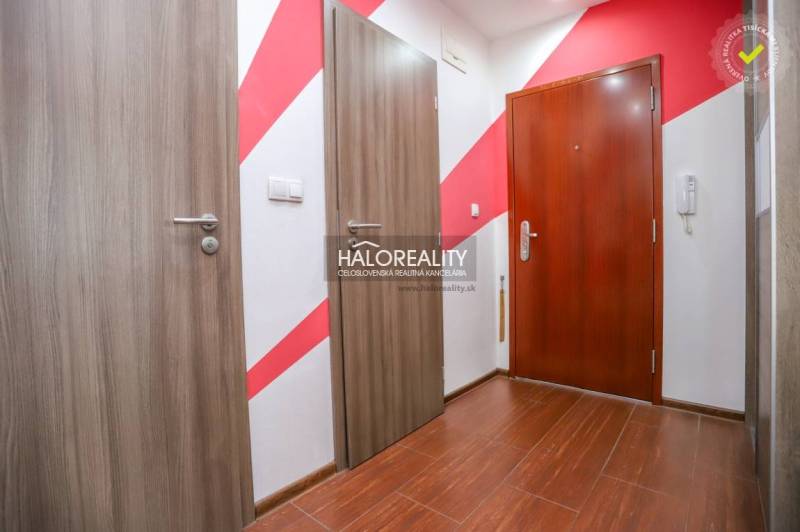 Előszoba egy 3 szobás lakásban fa dekor padlóval és színes fallal.