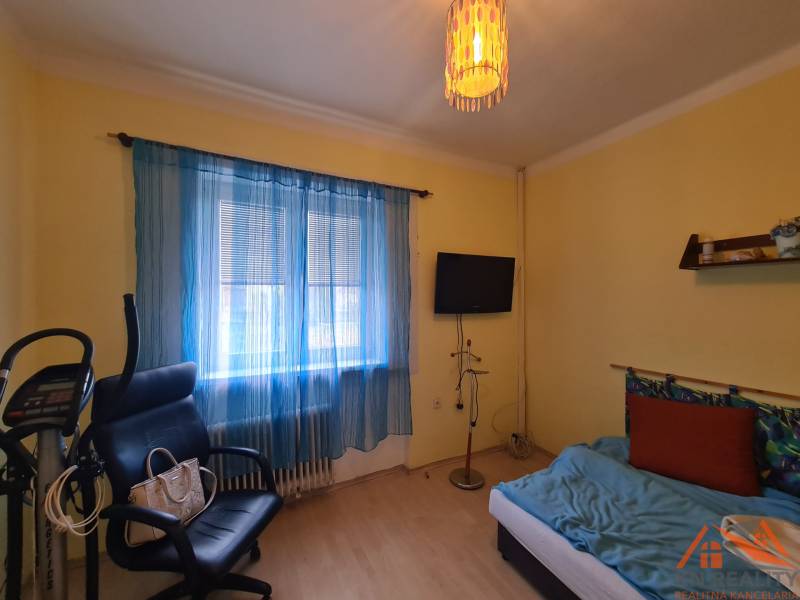 Szoba egy családi házban edzőfelszereléssel, székkel és televízióval.