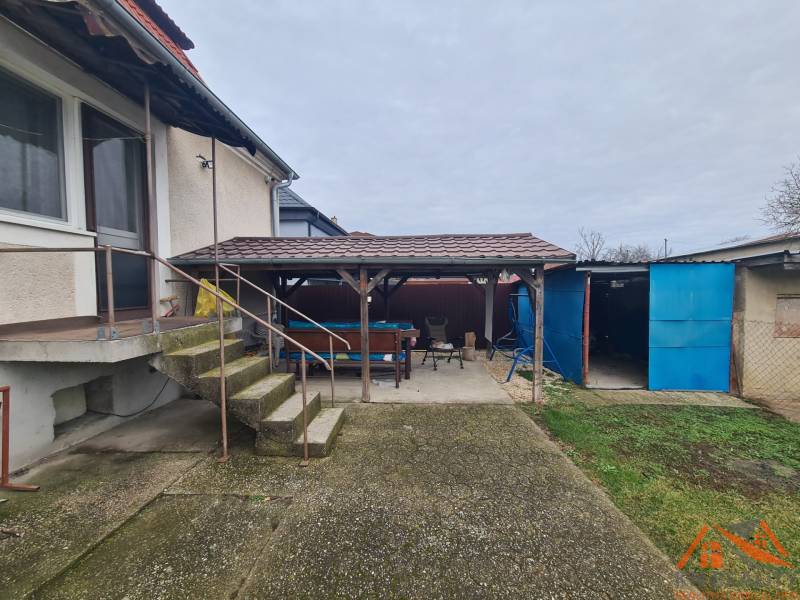 Családi ház Ógyallán tágas udvarral, előtetővel és külső lépcsőkkel.