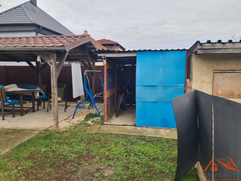 Családi ház kertje Hurbanovóban, filagória, fészer, kerékpár, hinta, füves terület.