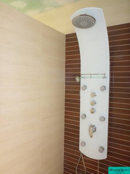 Zuhanypanel a csempézett falon egy családi házban.