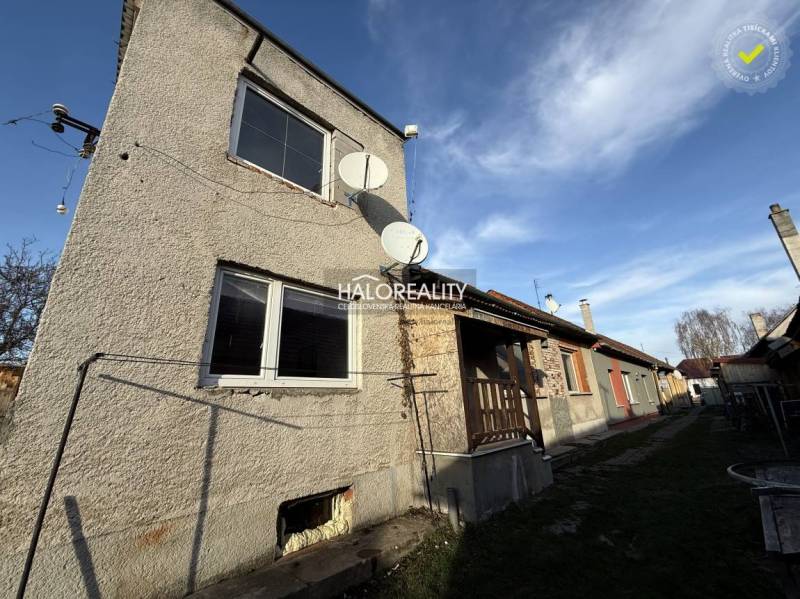 Családi ház Chynoranyban műholdakkal és kerttel, mellette további házak.