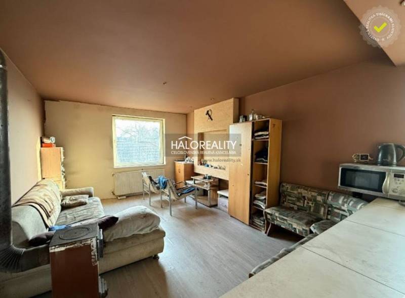 Nappali kanapéval, bútorokkal és konyhasarokkal egy családi házban.