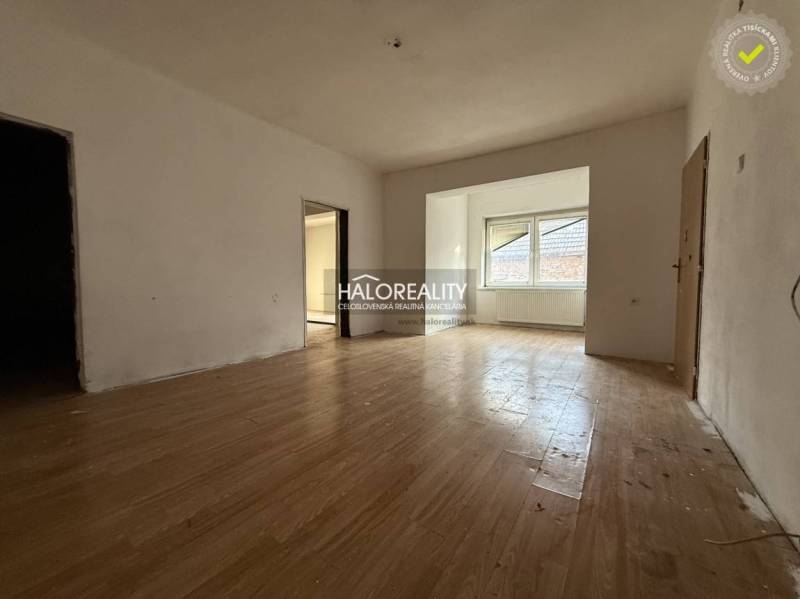 Családi ház belső tere fa dekorációjú padlóval és nagy ablakkal.