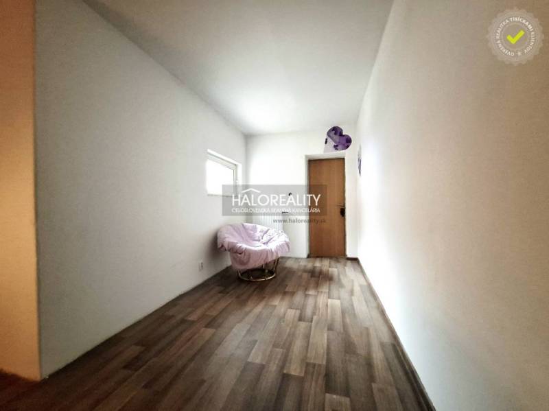 Szoba egy családi házban, székkel és fa dekorációjú padlóval.