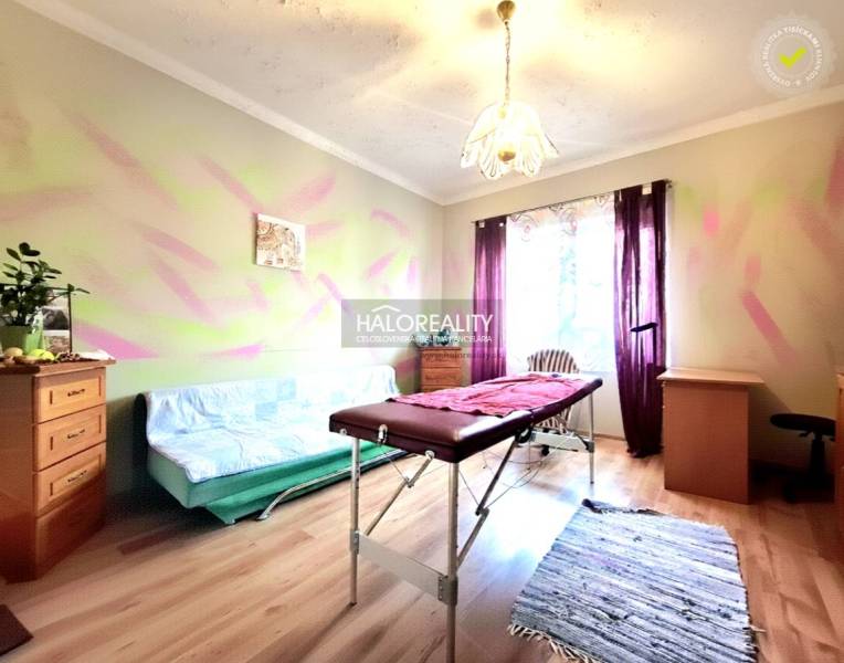 Szoba családi házban masszázsággyal és fa dekorációjú padlóval.