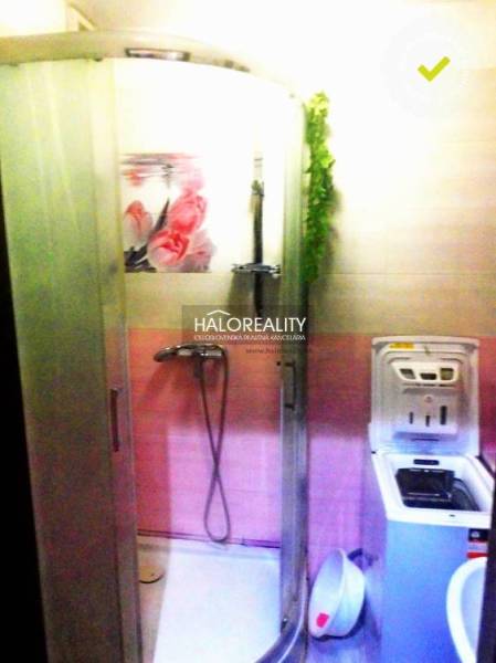 Fürdőszoba egy kétszobás lakásban zuhanyzóval és mosógéppel, rózsaszín árnyalatokkal.