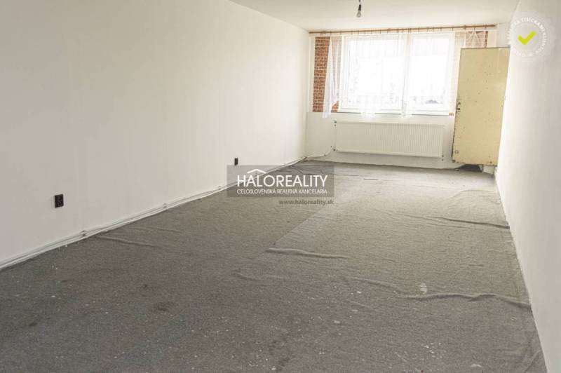 Üres üzlethelyiség szőnyeggel és nagy ablakkal, világos falakkal.