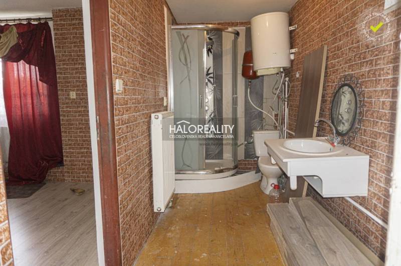 Fürdőszoba üzleti helyiségekben fa dekorációval a falakon és zuhanyzóval.