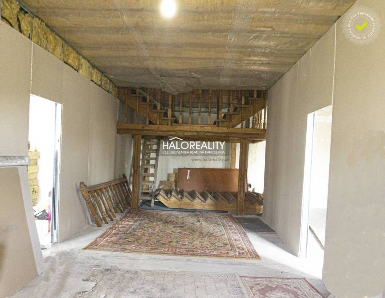 Kereskedelmi helyiségek belső tere fa lépcsővel és szőnyeggel.