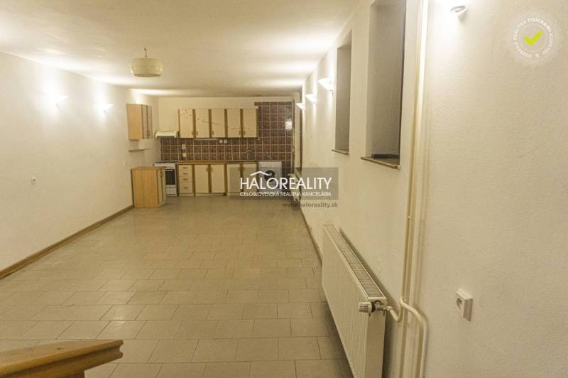 Tágas konyha és étkező egy családi házban, csempével és világos megvilágítással.