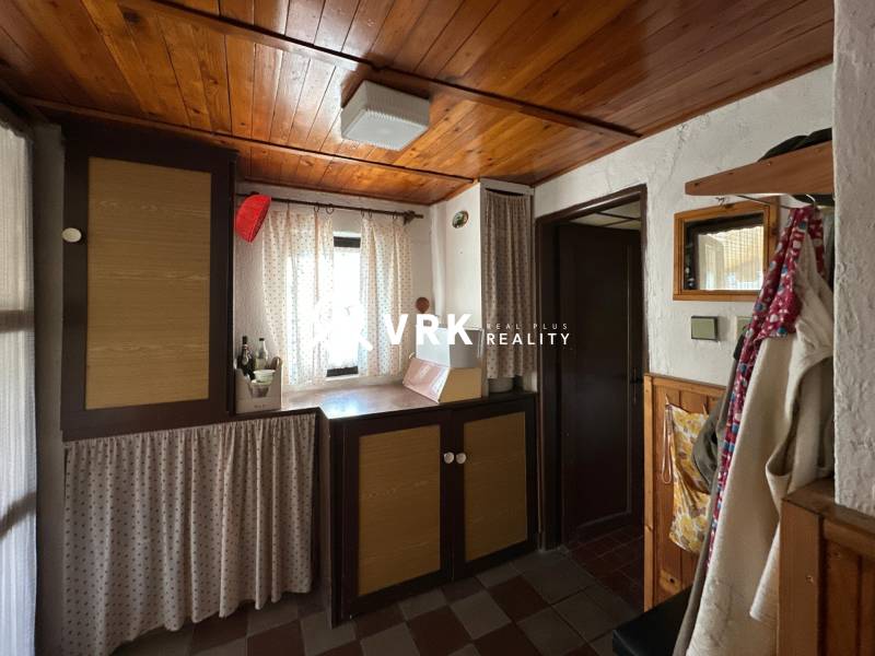 Családi ház belső tere fa mennyezettel és függönyökkel, hangulatos sarok dekorációs elemekkel.