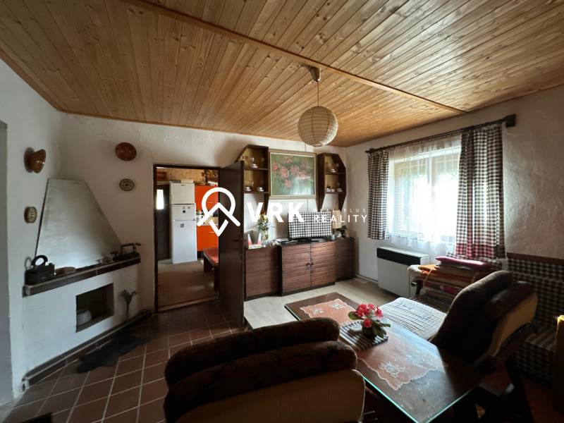 Nappali egy családi házban fa dekorációval a mennyezeten és otthonos bútorokkal.