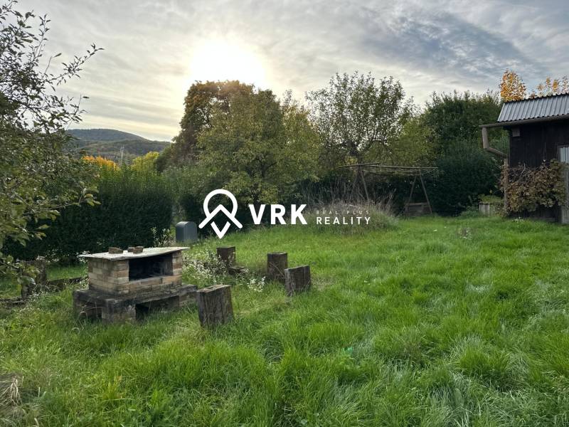 A családi ház kertje Kalšán, kandallóval és háttérben zölddel.