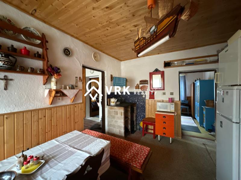 Családi ház belső tere fa mennyezettel és rusztikus berendezéssel.