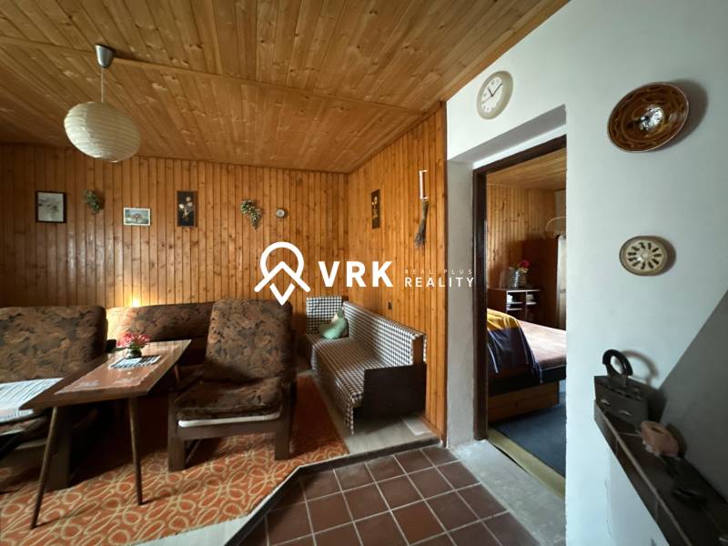 Családi ház belső tere fa burkolattal és kényelmes bútorokkal, retro dekorációkkal.