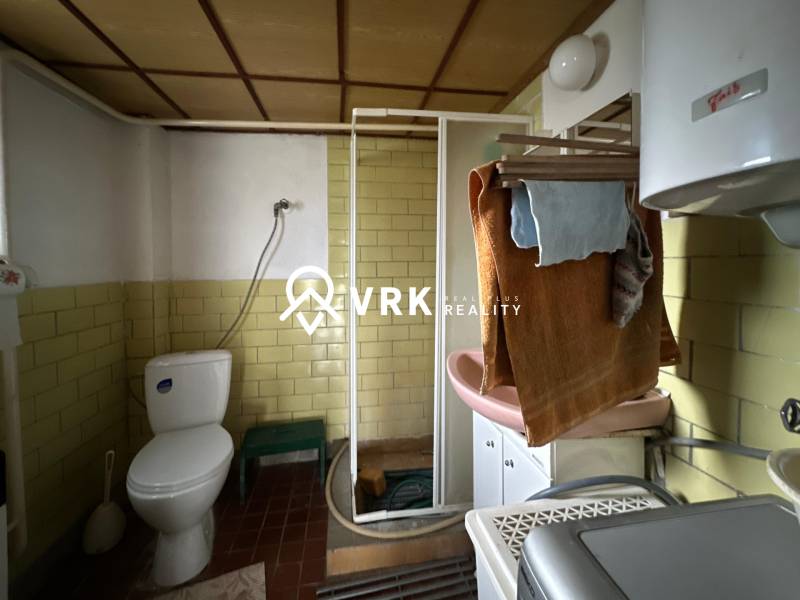 Fürdőszoba családi házban WC-vel, zuhanyzóval és mosdóval.