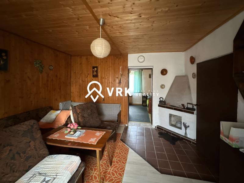 Nappali egy családi házban, fa dekorációval a falakon és a mennyezeten.