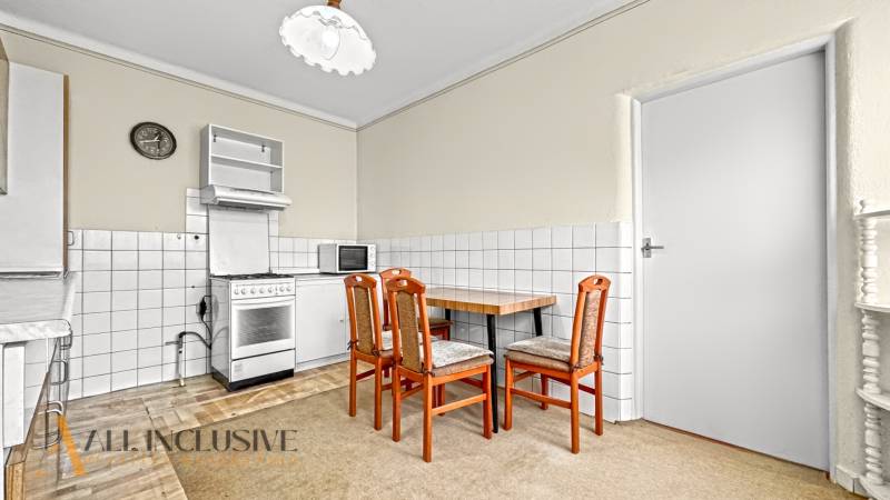 Konyha családi házban étkezőasztallal, székekkel és tűzhellyel.