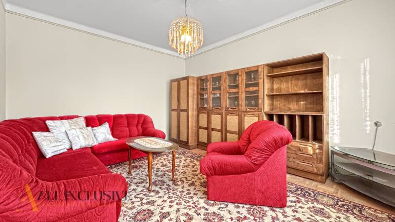 Családi ház nappalija piros ülőgarnitúrával és fa bútorzattal.