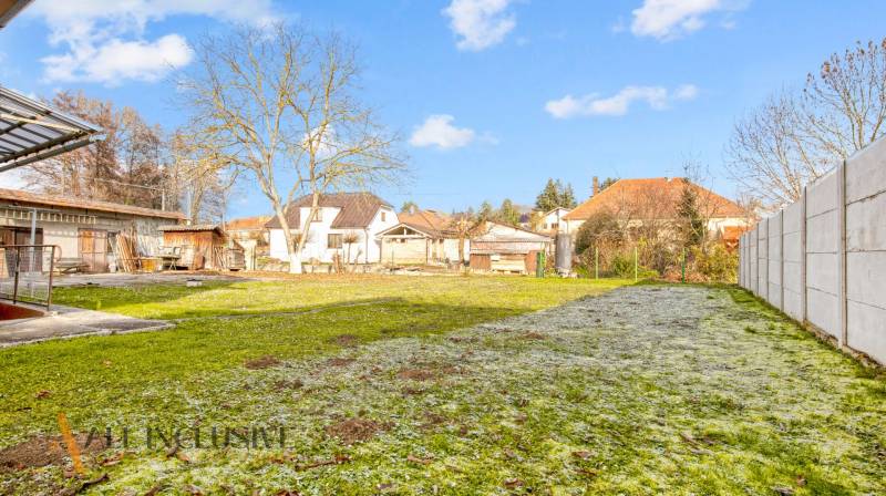 Kert a családi ház mellett a Nemečkovská utcán, Prašiceben, fákkal és gyepes területtel.