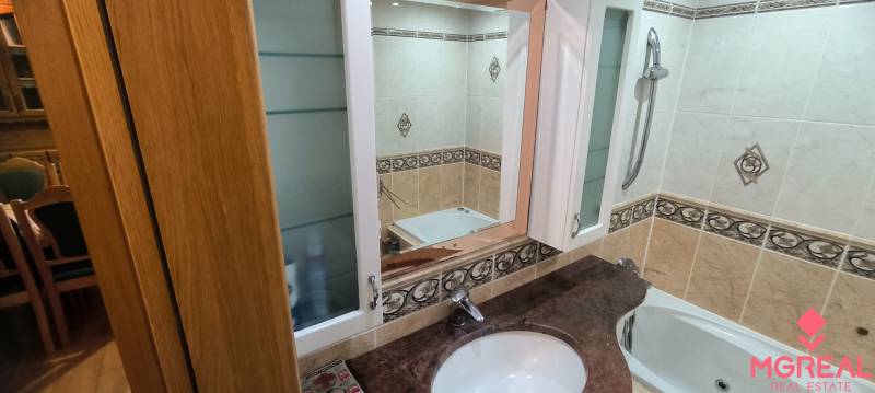 Fürdőszoba beépített szekrénnyel és tükörrel egy háromszobás lakásban.