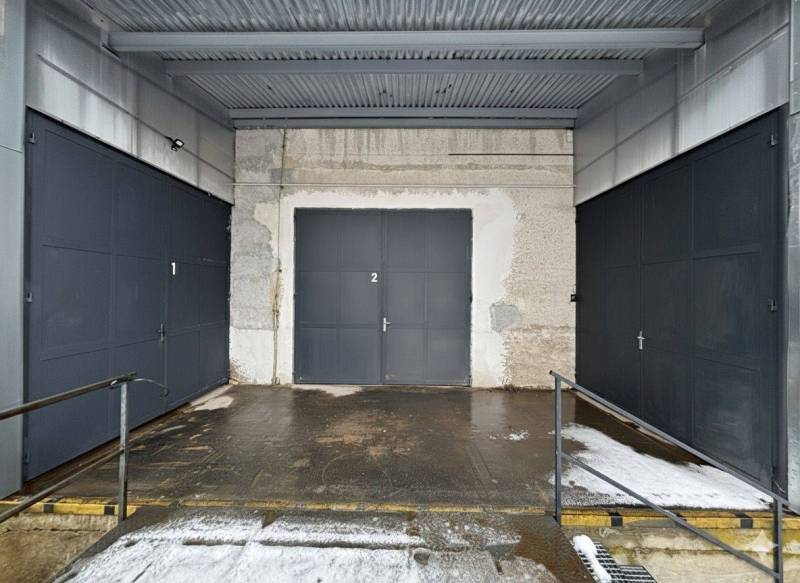 Három garázskapu fémkerítéssel a Poprádi Irodáknál.