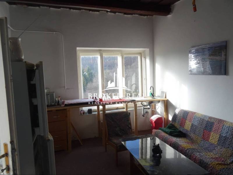 Nappali kanapéval és kilátással kifelé, Családi ház egyszerű berendezéssel.