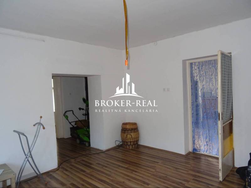 Nappali tér egy családi házban fa dekorációjú padlóval és fehér falakkal.