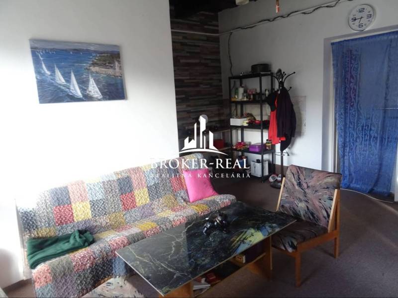 Nappali egy családi házban színes kanapéval, dohányzóasztallal és fali képpel.