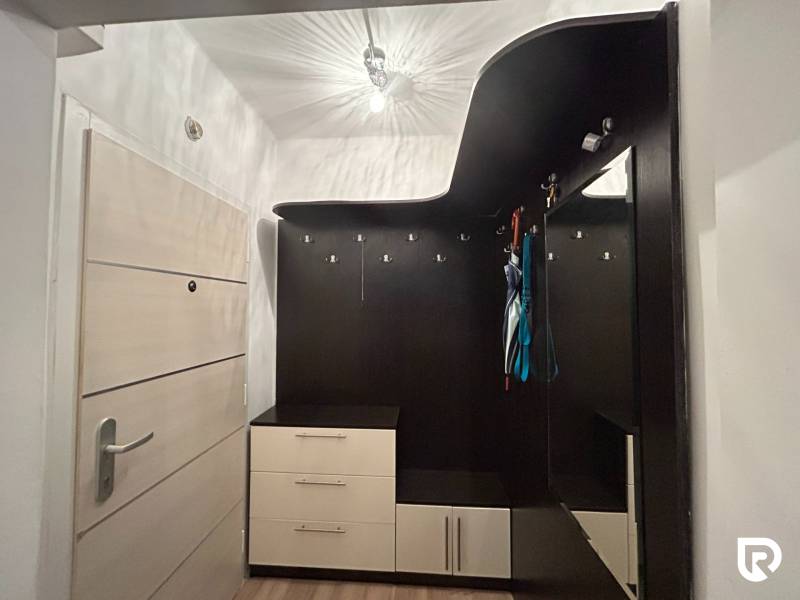 Előszoba praktikus bútor megoldással egy egyszobás lakásban, fa dekor padlóval.