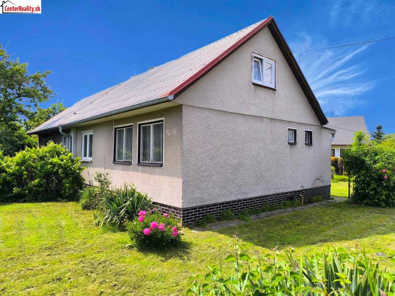 Családi ház Nyitrán fehér homlokzattal és zöldellő kerttel.