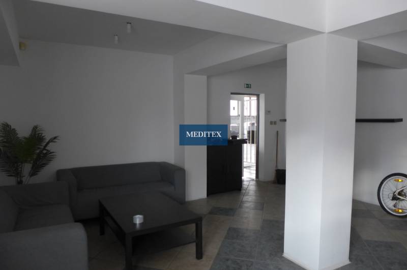 Nappali szürke kanapékkal, asztallal és csempézett padlóval a raktárakban és csarnokokban.