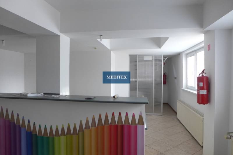 Raktárak és csarnokok belső tere recepciós pulttal, amelyet színes ceruzák és tűzcsap díszít.