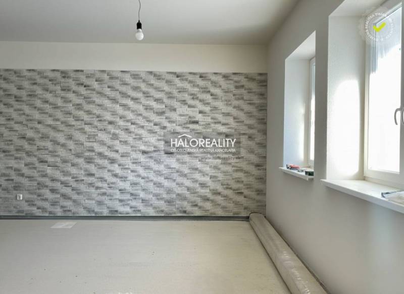 Családi ház belső tere texturált fallal és fapadló dekorációval, amely még nincs telepítve.